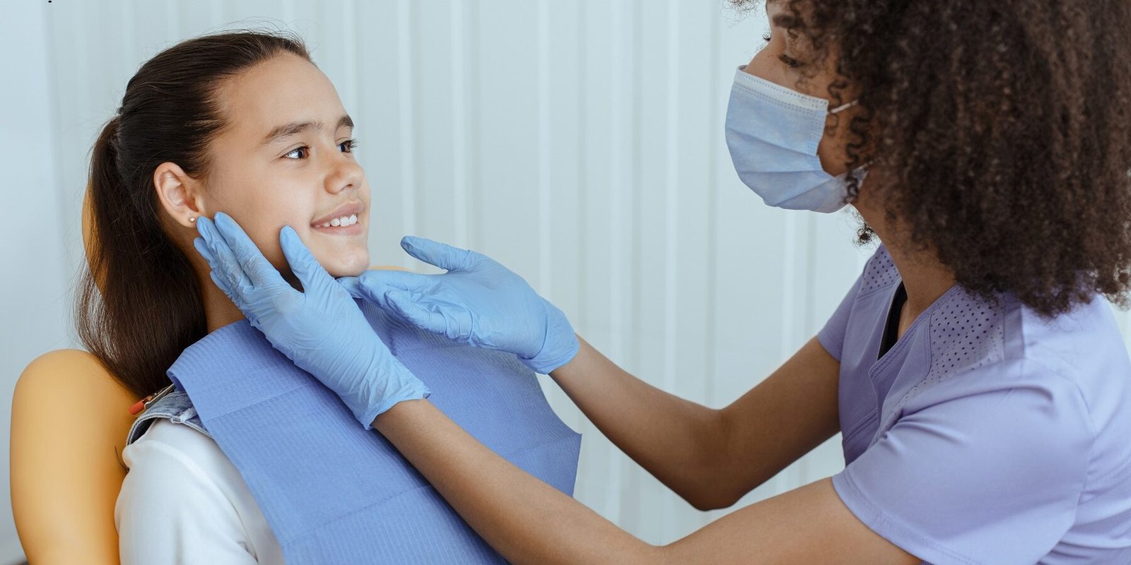 Little kid sit in dental chair at medical center, professional doctor fixing her teeth