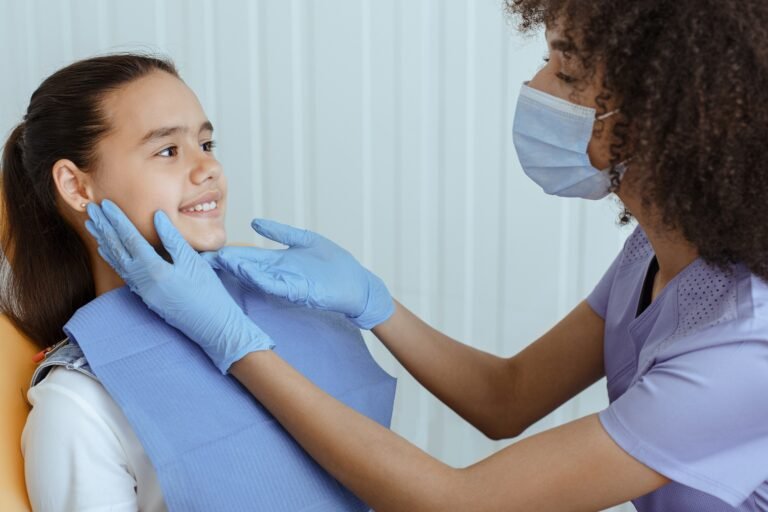 Little kid sit in dental chair at medical center, professional doctor fixing her teeth