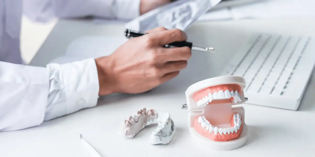 Scrivania di un ortodontista con una impronta dentale (arcata inferiore) ed un modellino completo con le due arcate dentali. Nello specifico utilizzate per parlare di classificazione di angle